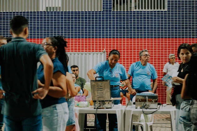 Participantes reunidos junto às mesas durante o evento da campanha