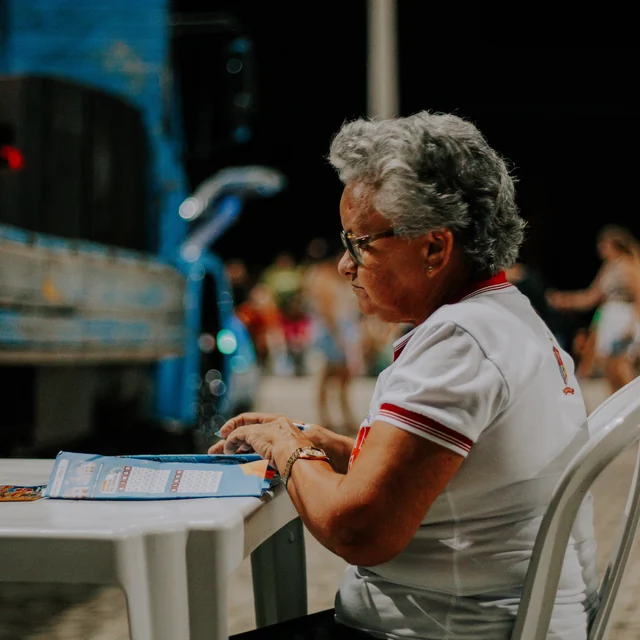Participante acompanhando a campanha com uma cartela sobre a mesa